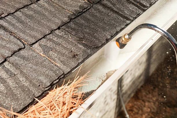 Gutter being flushed clean of leaves and debris